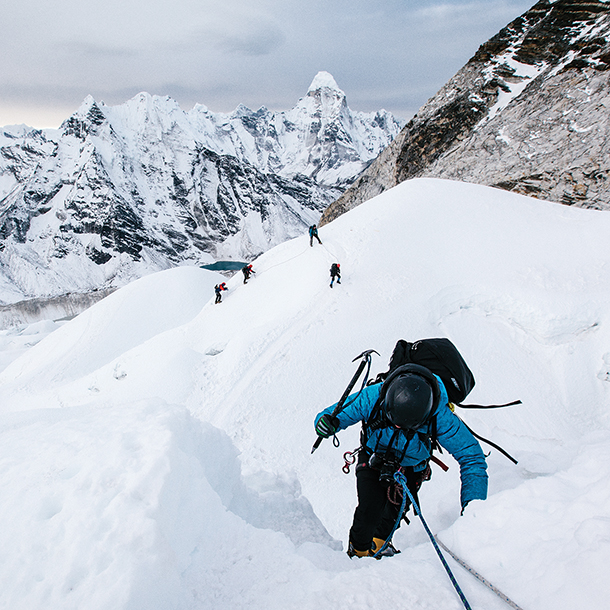 Mountain climbers hiking up snow covered mountain